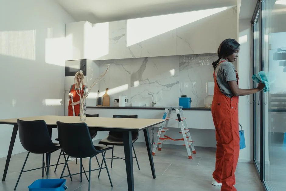 A person cleaning a kitchen shelf with a spray bottle and cloth, keeping it hygienic and spotless.